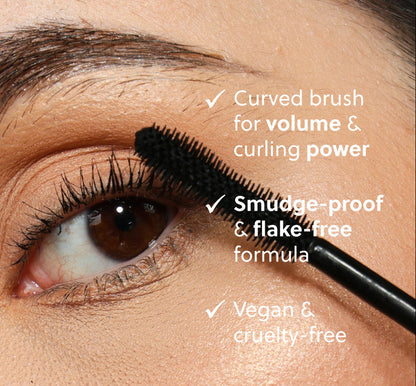 Eyelash mascara being applied with a curved brush, highlighting features like volume, curling power, smudge-proof formula, vegan, and cruelty-free status.